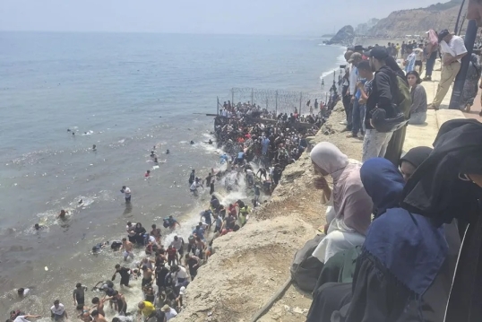 Migrantes: Miles de jóvenes entran en Ceuta a pie por el espigón fronterizo