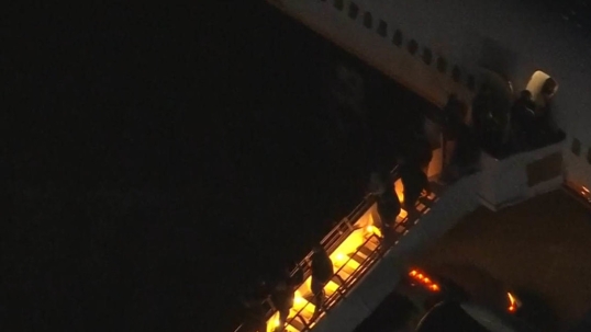 El presidente Maduro saliendo del avión, esposado y acompañado por personal militar
